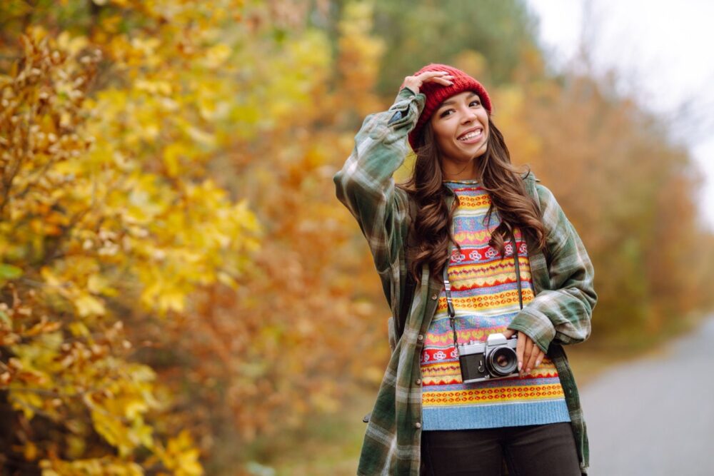 Gyönyörű fiatal nő fényképezkedik retro kamerával. Pihenés, kikapcsolódás, utazás, életstílus.